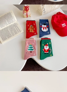 Christmas socks with festive snowman and Santa patterns on a white table display
