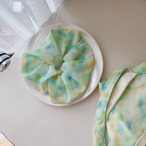 Detail of mint green watercolor chiffon scrunchie and matching tie-dye fabric pouch