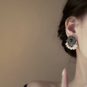 Orecchini vintage con gemma nera e nappe di perle bianche pendenti indossati da modella
