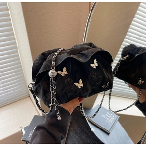 Detailed close-up of a black pleated cloud bag featuring silver butterfly metal ornaments