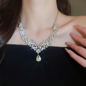 Close-up of sparkling V-shaped rhinestone necklace with teardrop pendant on model