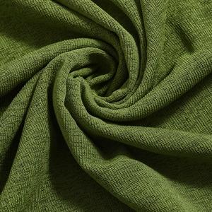 Detail of green knitted mesh fabric with spiral pleats and intricate textile texture