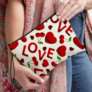 White canvas pouch with red Love and cherry print held by model against light background