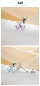 Macro detail of heart-shaped zircon cartilage earrings with screw flat back design