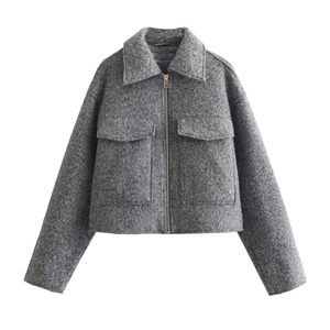 Close-up of the grey wool blend fabric texture and metal zipper on the short jacket
