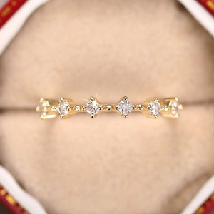 Vista detallada de un anillo de oro con circonitas en un joyero rojo elegante