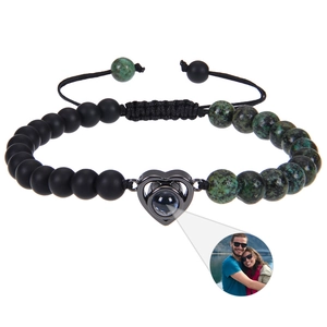 Detail of custom heart projection bracelet with black matte beads and green textured stones