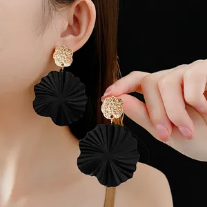 Minimalist geometric floral drop earrings with gold hammer texture and black matte petals