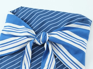Detailed close-up of blue and white striped linen fabric featuring a large central knot tie