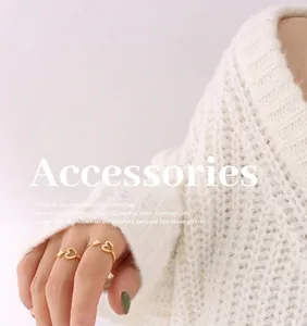 Close-up of minimalist gold heart open ring worn with a soft white knit sweater