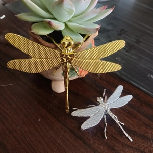 Detailed macro view of vintage dragonfly lid holders in gold and silver finishes