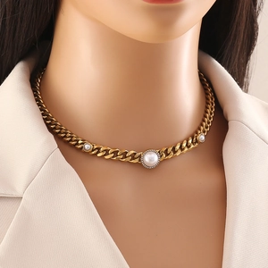 Gold-plated Cuban chain necklace with sparkling diamonds and central pearls on a model