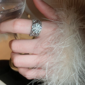 Gros plan macro d'une bague fleur en argent et zircone au doigt, style élégant