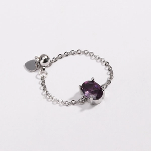 Detail of silver chain ring with purple oval zircon and small heart pendant