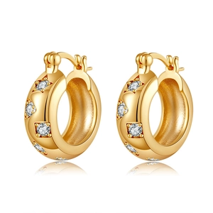Macro shot of gold-plated star hoop earrings with sparkling cubic zirconia settings
