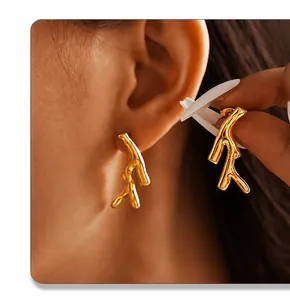 Detailed view of irregular golden tree branch earrings with PVD plated metal texture