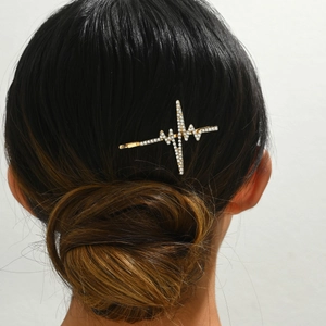 Golden rhinestone heart monitor hairpin elegantly styled on a bun for women