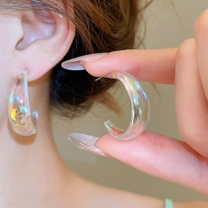 Detail showing colorful iridescent C-shaped acrylic earrings with silver posts for women