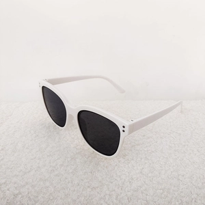Detail view of white acetate sunglasses frame with metal rivets and dark lenses