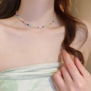 Detailed close-up of colorful beaded choker necklace with silver accents on model neck