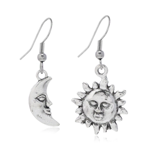 Détail de boucles d'oreilles vintage en alliage argenté avec visages soleil et lune