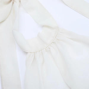 Nahaufnahme der plissierten Dekolleté-Details und feinen Nähte am weißen Netzkleid