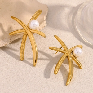 Macro view of 18K gold plated palm tree pearl stud earrings with polished finish