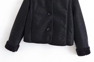 Détail de veste noire en daim synthétique avec bordures en polaire sur les poignets