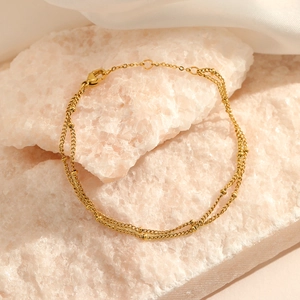 Double-layered gold bead bracelet in stainless steel with adjustable lobster clasp on pink stone