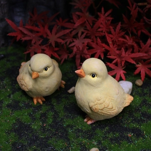 Pair of realistic resin baby chick miniatures on green moss with autumn maple leaves