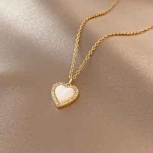 Elegant gold titanium necklace featuring a heart shell pendant with sparkling crystals