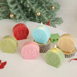 Christmas snowman and Santa embossed round candles in six colors with festive pine decor