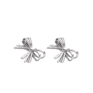 Macro shot of silver bow stud earrings in polished stainless steel with elegant details