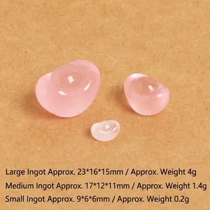 Close-up of three translucent pink resin gold ingots in small, medium, and large sizes