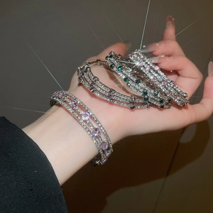 Detailed view of silver zircon bracelet featuring layered crystals and pink stones on wrist