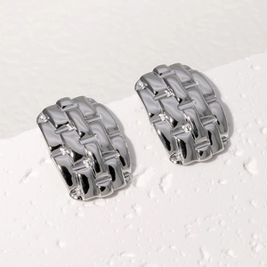 Macro shot of silver woven texture stainless steel earrings with metallic luster finish