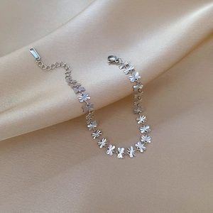 Close-up of polished stainless steel clover chain bracelet with adjustable lobster clasp