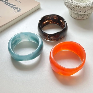 Chic irregular resin wide bangles in tortoiseshell and marble patterns on art props