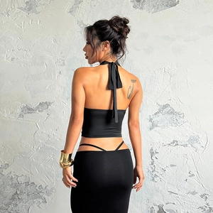 Detail of black halter backless crop top and bodycon skirt showing rear cut-out design