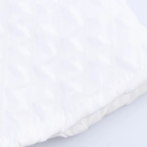 Elegant white dress detail with premium diamond quilted texture and hand-stitched floral accents