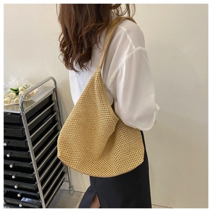 Close-up of khaki woven shoulder bag with hollow knit texture worn by a model