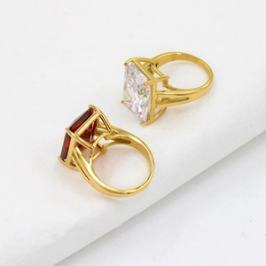 Dettaglio macro di anelli vintage con zirconi quadrati rossi e bianchi placcati oro