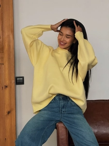 Chic yellow crewneck oversized sweater with long sleeves paired with blue denim jeans