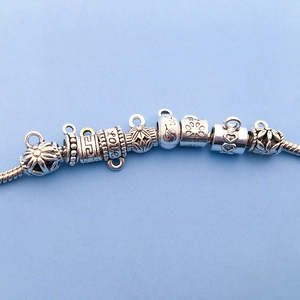 Détails de perles argentées antiques avec motifs de cœur et gravure Love sur un bracelet