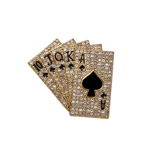 Broche poker royal flush dorée sertie de strass blancs sur un fond minimaliste