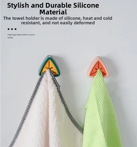 Detail of triangular silicone towel plugs in pink and green with self-adhesive wall mount