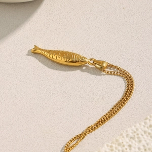 Vue macro d'un pendentif saumon en or 18 carats avec écailles sur une chaîne à maillons
