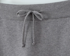 Close-up of grey knit skirt featuring elastic ribbed waistband and adjustable drawstring