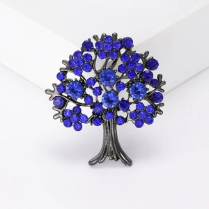 Detail of life tree brooch with blue rhinestones on dark gunmetal finish for apparel
