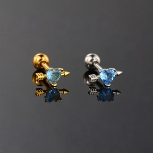 Detailed shot of gold and silver heart cupid arrow stud earrings with blue zircon stones